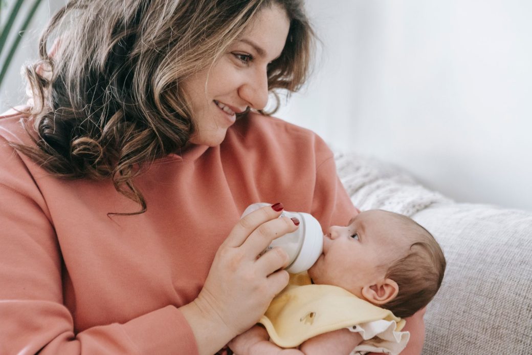 Close-up of a mother breastfeeding her baby outdoors, highlighting the bond and care.