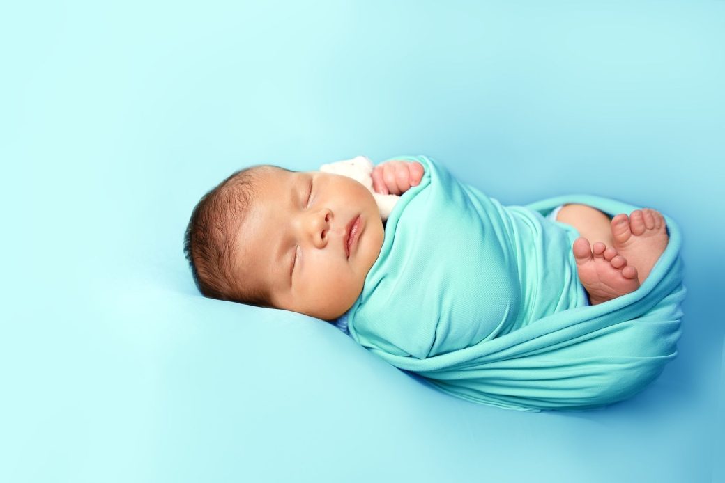 Peaceful newborn baby sleeping soundly in a cozy blanket.